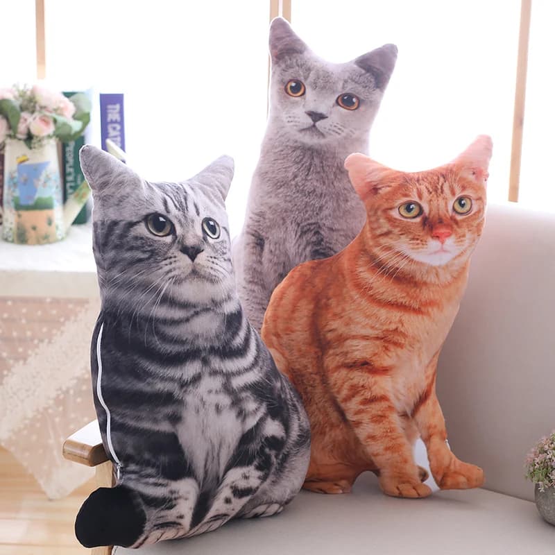 Três almofadas de pelúcia gatos sentados realistas cinza, laranja e cinza escuro em sofá