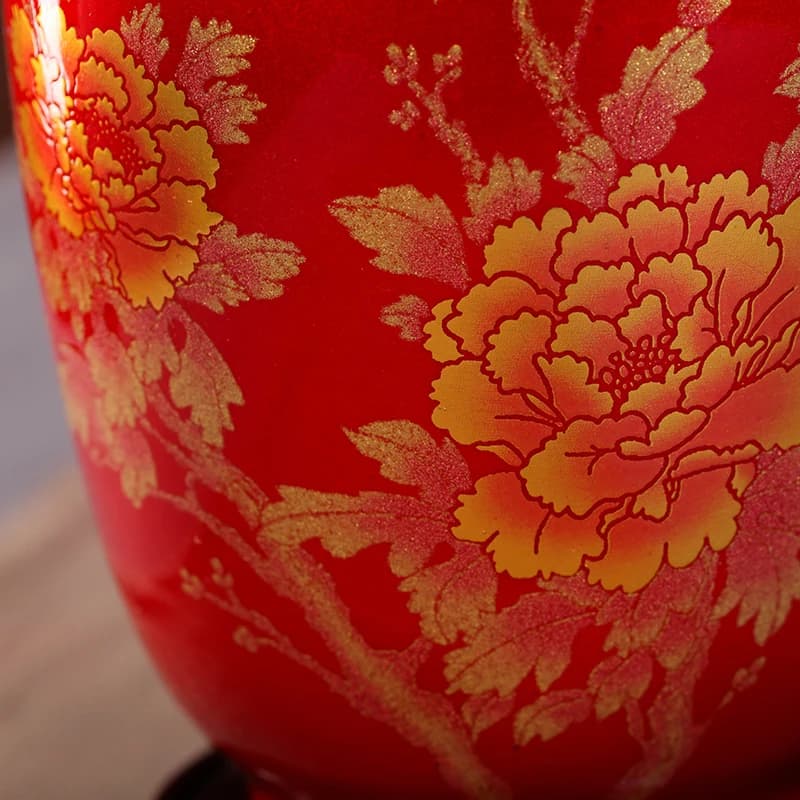Close em flores douradas detalhadas no vaso decorativo Jingdezhen de porcelana vermelha brilhante