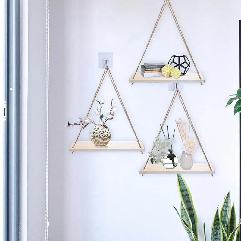 Conjunto de 3 prateleiras suspensas de madeira com corda de cânhamo decorando parede com vasos e livros