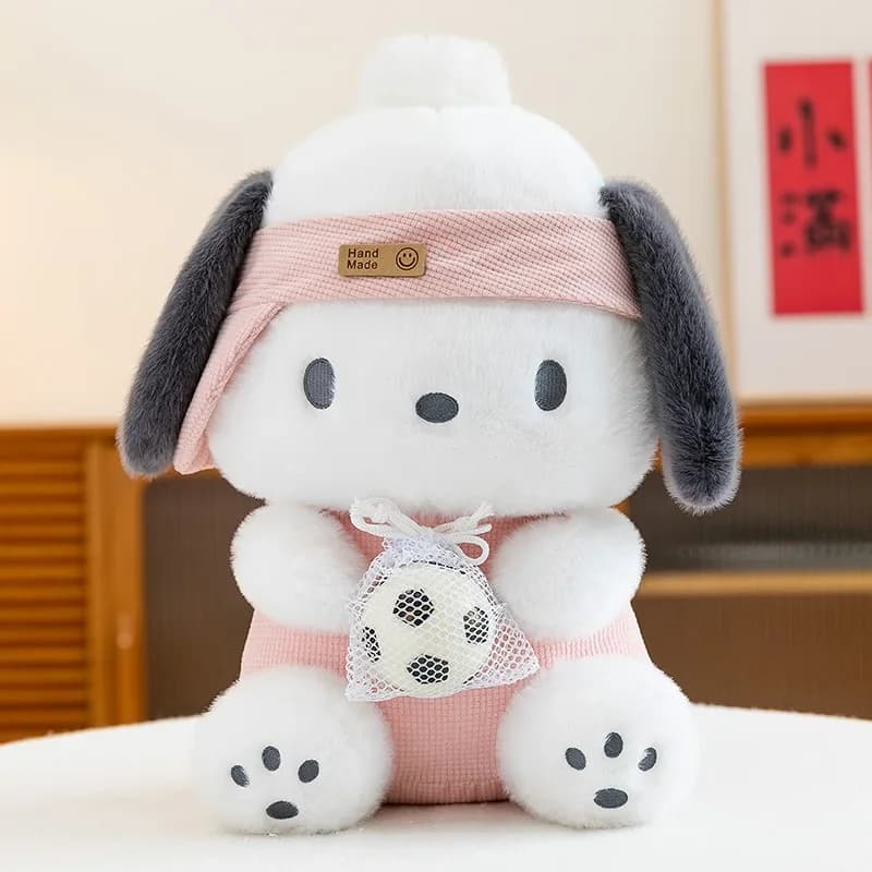 Boneco de pelúcia Pochacco branco com orelhas cinza, roupa rosa e faixa na cabeça, segurando bola de futebol