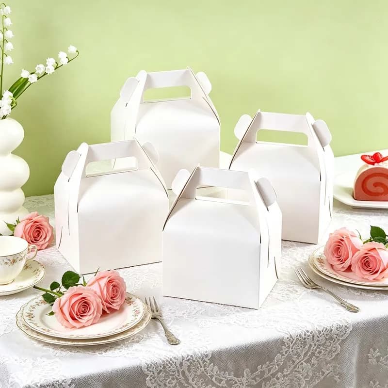 Caixas de presente brancas de papel kraft com alça na tampa decorando mesa com flores e bolo