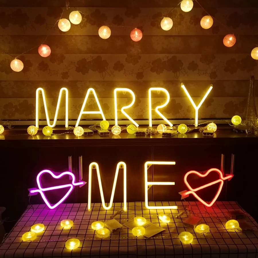 Luz neon decorativa multicolor letras MARRY ME com corações LED em ambiente festivo