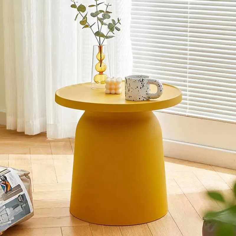 Mesa de centro amarela redonda minimalista com vaso e caneca na sala de estar