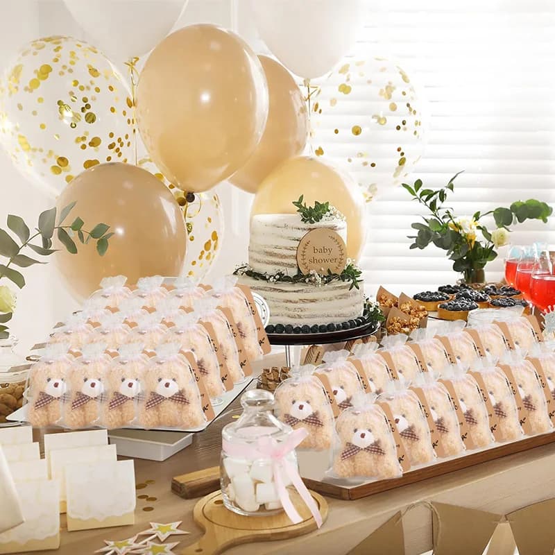 Lembrancinhas ursinhos de pelúcia em saquinhos de organza em mesa decorada para festa com balões dourados