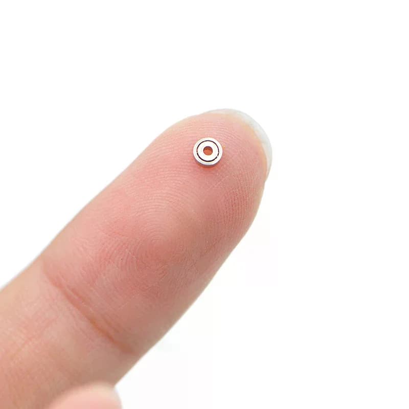 Rolamento de esferas miniatura 681ZZ em metal prateado sobre ponta do dedo para mostrar tamanho