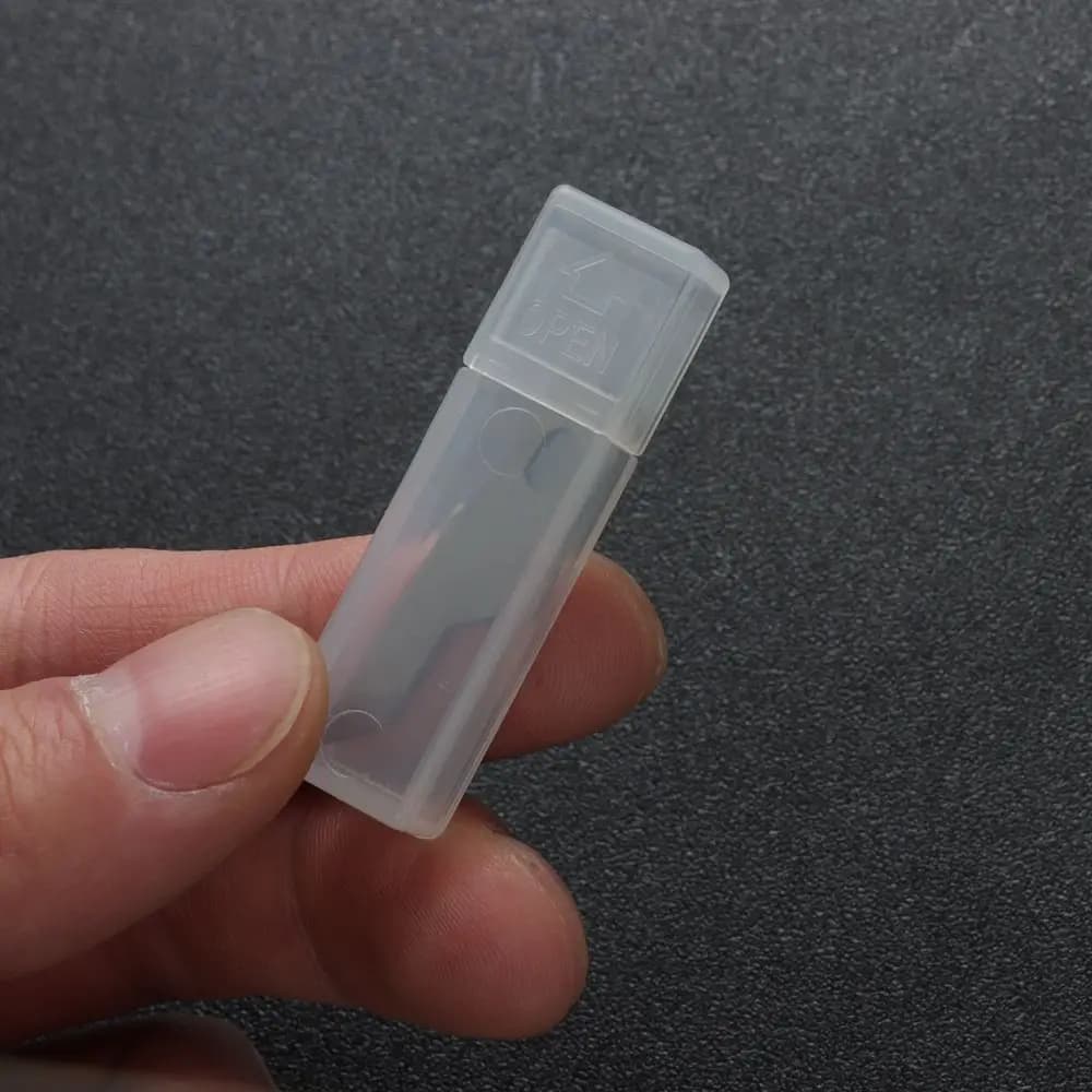 Estojo plástico transparente com lâminas de bisturi de precisão em metal prata para uso manual