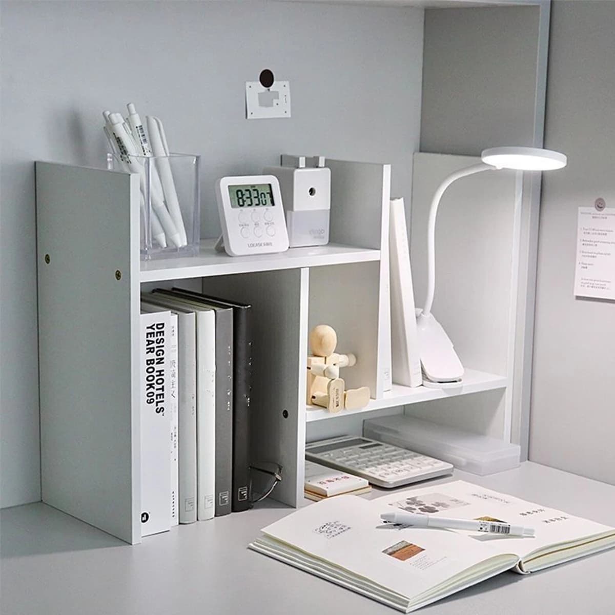 Estante de livros expansível branca minimalista ajustável com livros e objetos de mesa