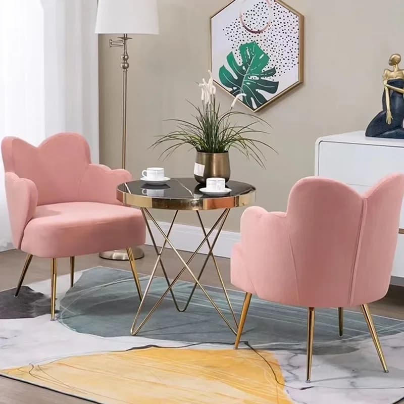Mesa de centro redonda de vidro com base metálica em ouro, poltronas de veludo rosa, ambiente de sala de estar