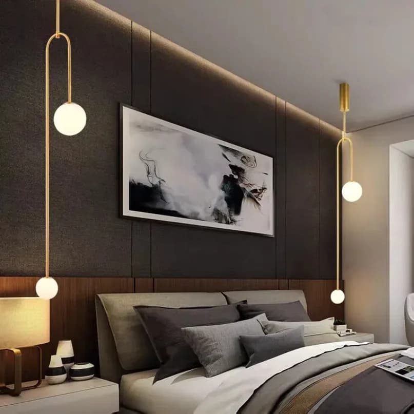 Luminária pendente dourada com esferas de vidro branco, design moderno, instalada em quarto elegante