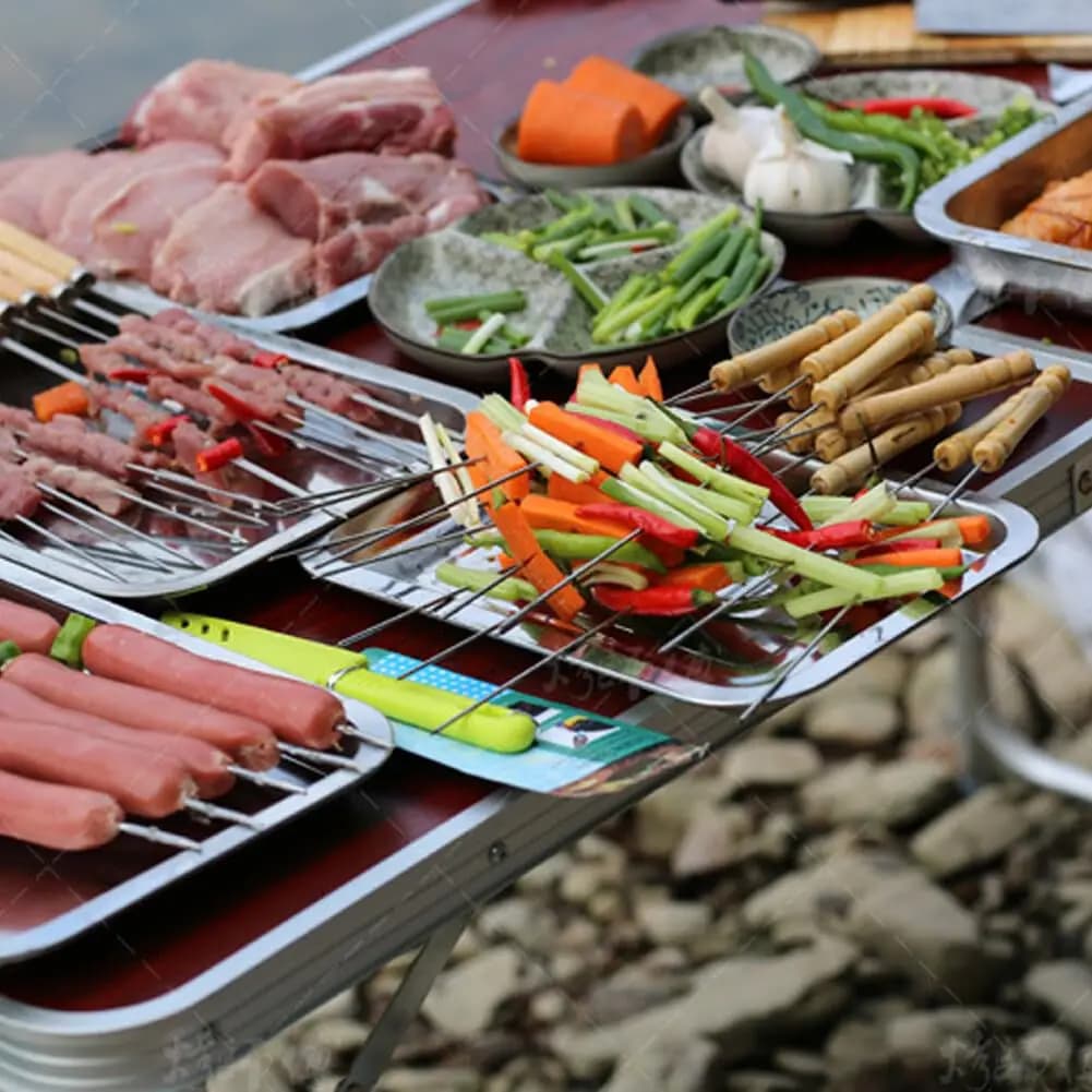 Espetos para churrasco Jácotei com cabos de madeira usados para espetar legumes e carnes em mesa de preparo