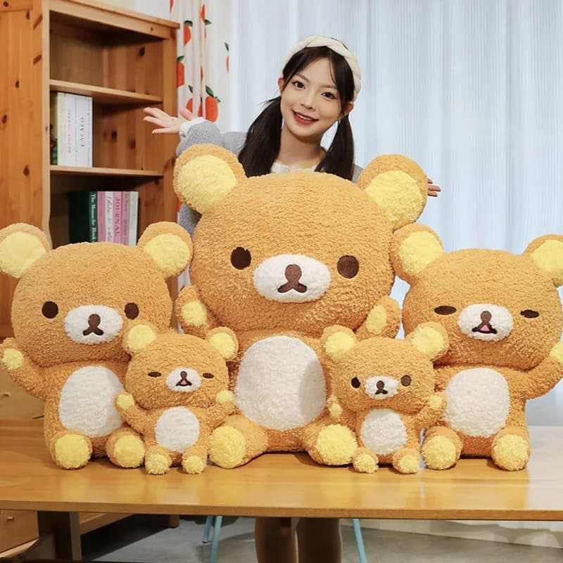 Mulher sorrindo com coleção de 5 ursos de pelúcia Rilakkuma marrons de vários tamanhos