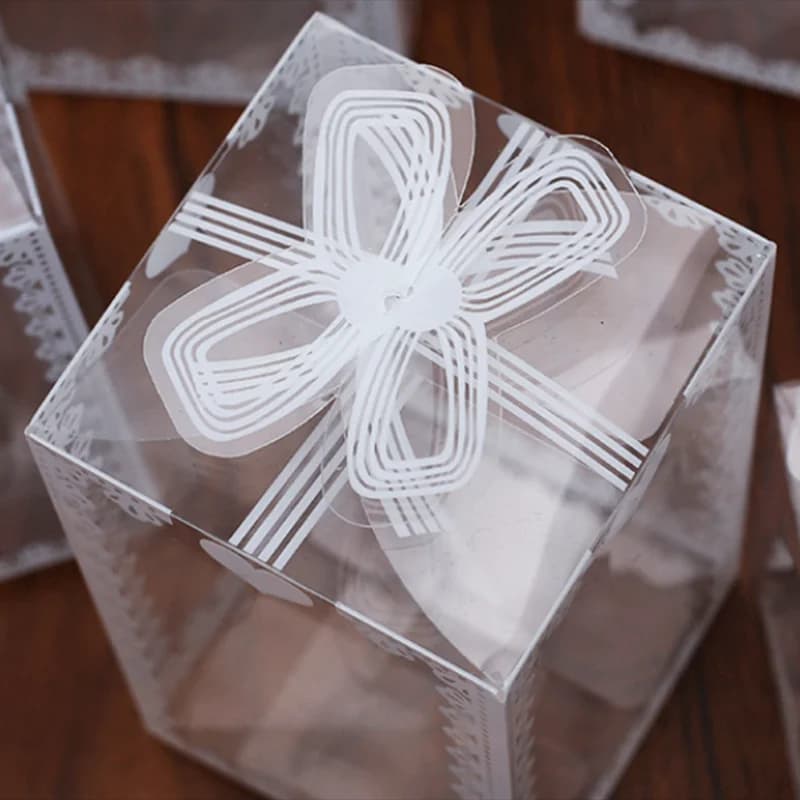 Caixa para lembrancinhas transparente em PVC com estampa branca de laço e detalhes delicados