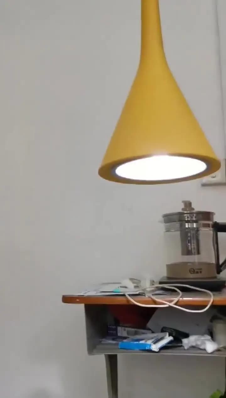 Luminária pendente moderna amarela com luz LED direcionada para baixo em ambiente interno