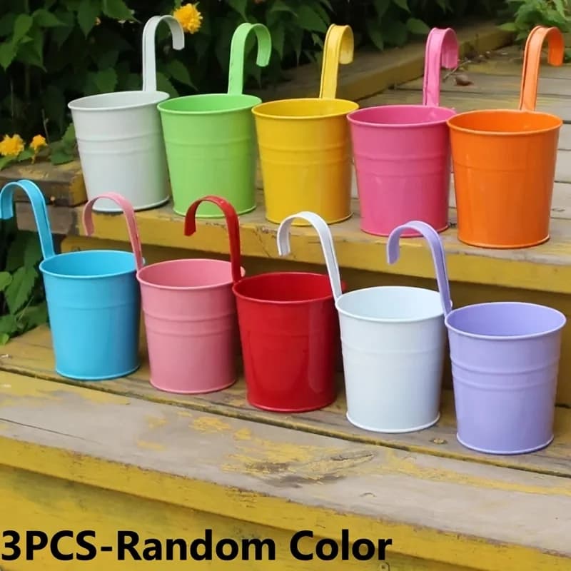 Vasos de metal suspensos multicoloridos em um degrau de madeira