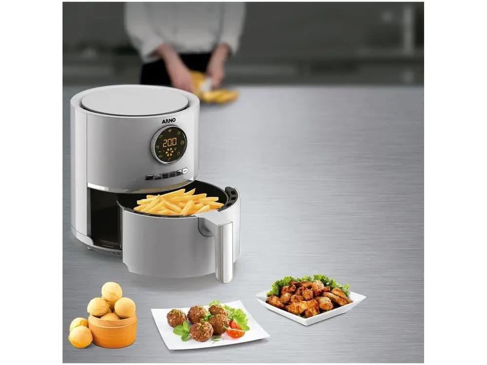 Fritadeira elétrica Arno Air Fryer inox digital com cesta aberta e pratos de petiscos preparados ao lado