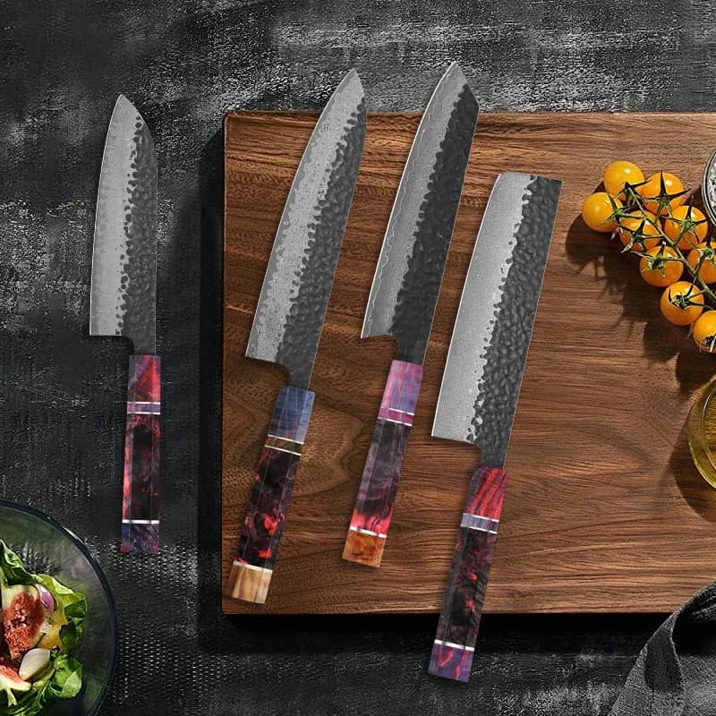 Conjunto de facas de cozinha em aço damasco com cabos de madeira multicoloridos em tábua de corte