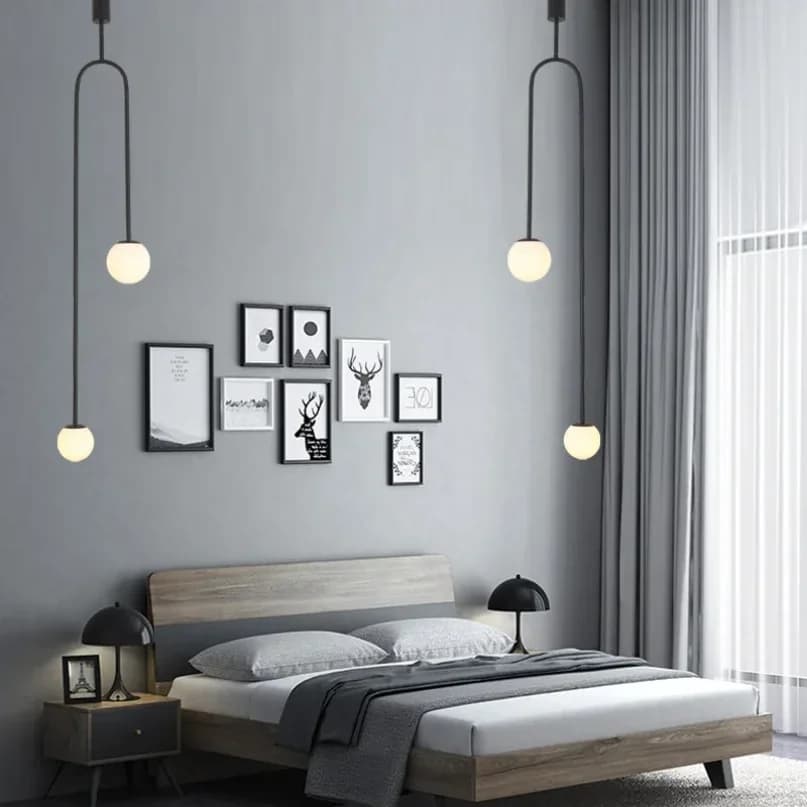 Luminária pendente com estrutura preta e esferas de vidro branco, design contemporâneo em quarto minimalista