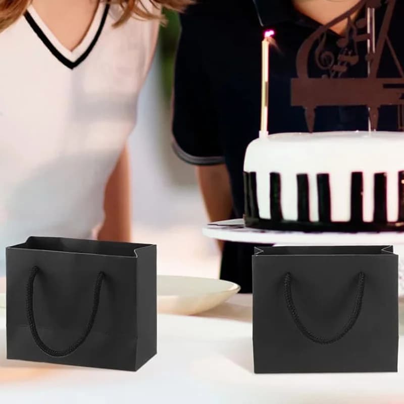 Sacos de presente de papel preto com alças, pilha de 10 peças, fundo branco