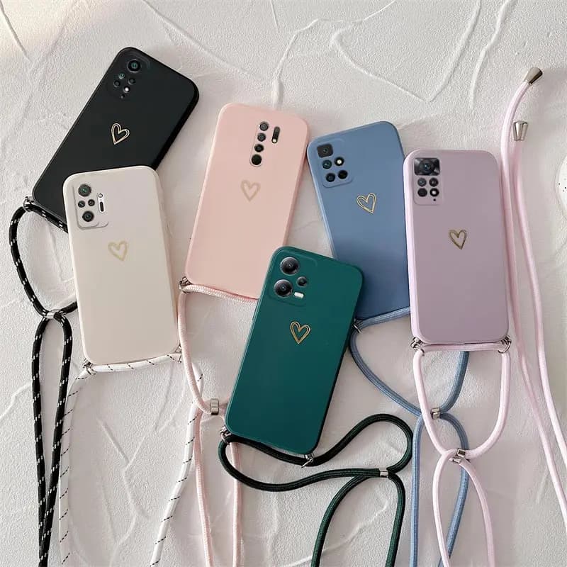 Capas de telefone de silicone com design de coração em relevo em várias cores, com alça crossbody, dispostas em uma superfície branca