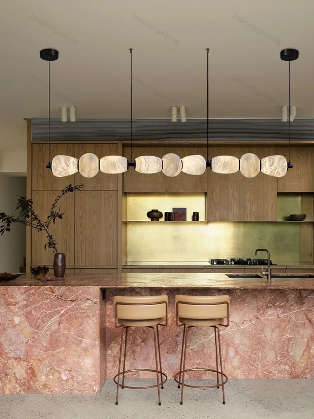 Lustre linear preto com pedras de mármore iluminadas em cozinha moderna com ilha de mármore rosa