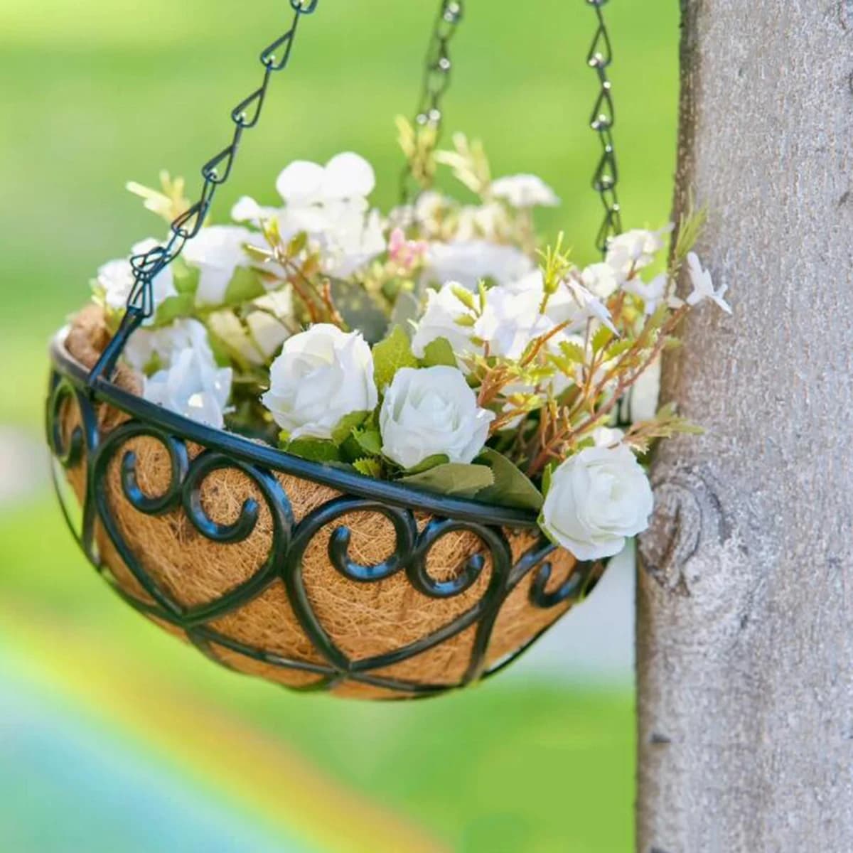 Vaso suspenso Jácotei redondo ferro com base de fibra de coco marrom decorado com flores brancas