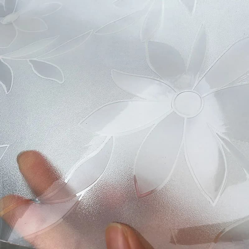 Detalhe do tapete de mesa redondo em PVC transparente com textura floral e toque macio