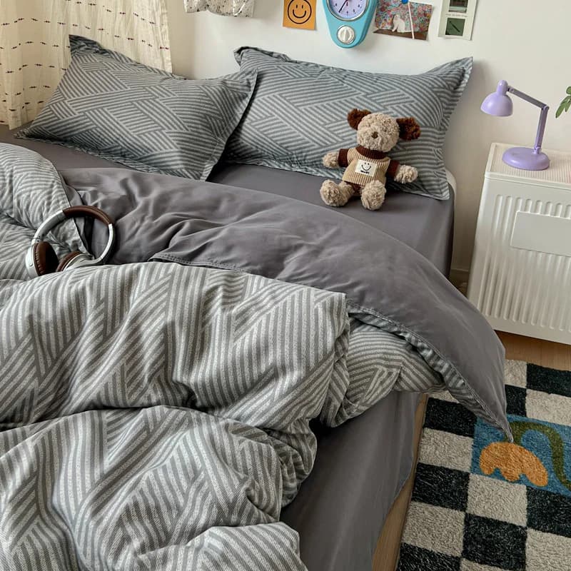 Conjunto de cama 4 peças cinza com fronhas e edredom estampado em padrão geométrico chevron