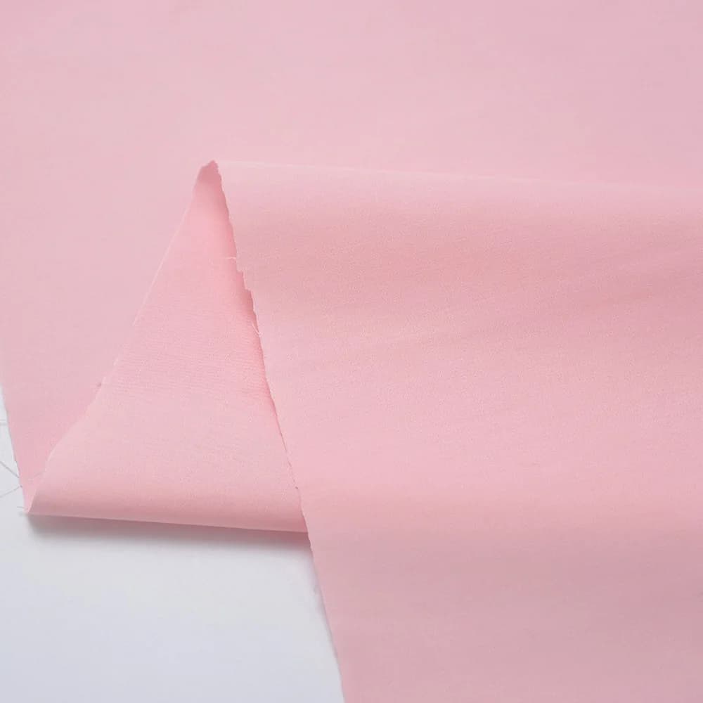 Tecido de popeline de algodão sólido em várias cores com um vestido infantil vermelho ao lado
