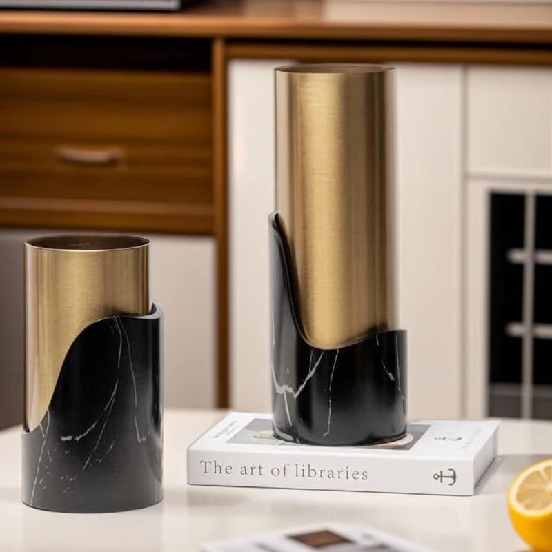 Vasos decorativos Jácotei com design minimalista base em mármore preto e corpo metálico dourado