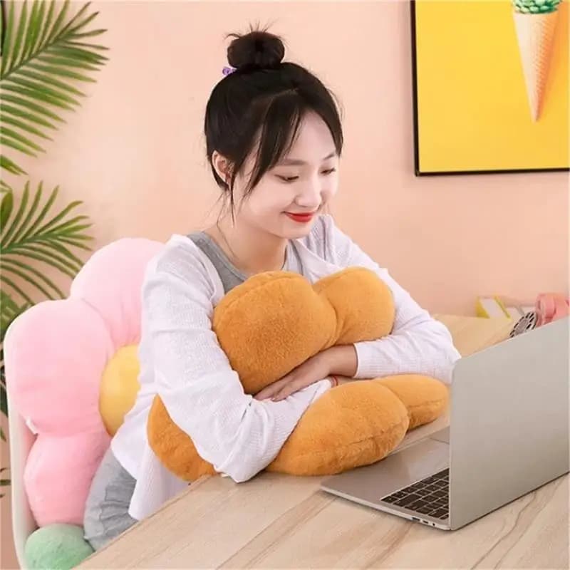 Mulher usando almofada de pelúcia flor girassol marrom para conforto enquanto trabalha no laptop