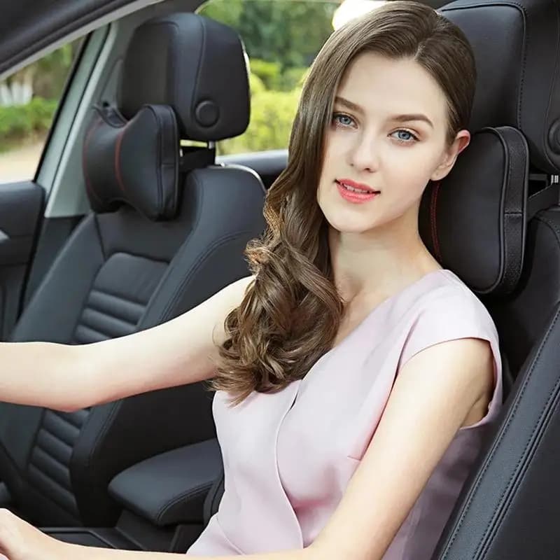 Almofada de pescoço para carro preta com detalhes vermelhos instalada em banco automotivo com mulher ao volante