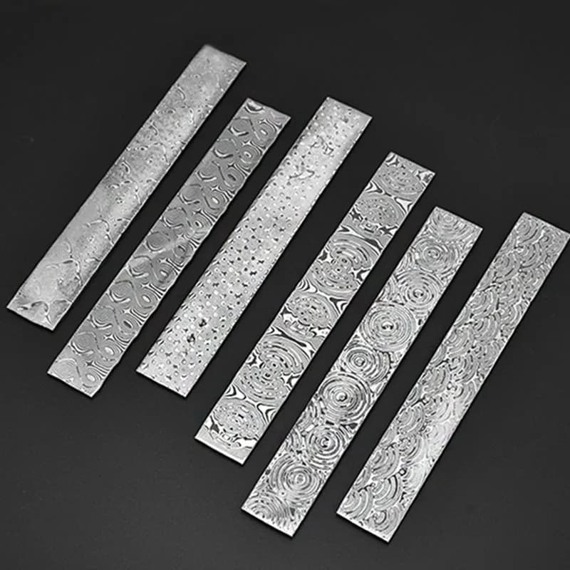 Seis lâminas de aço Damasco com padrões variados, fundo preto, tratamento térmico visível.