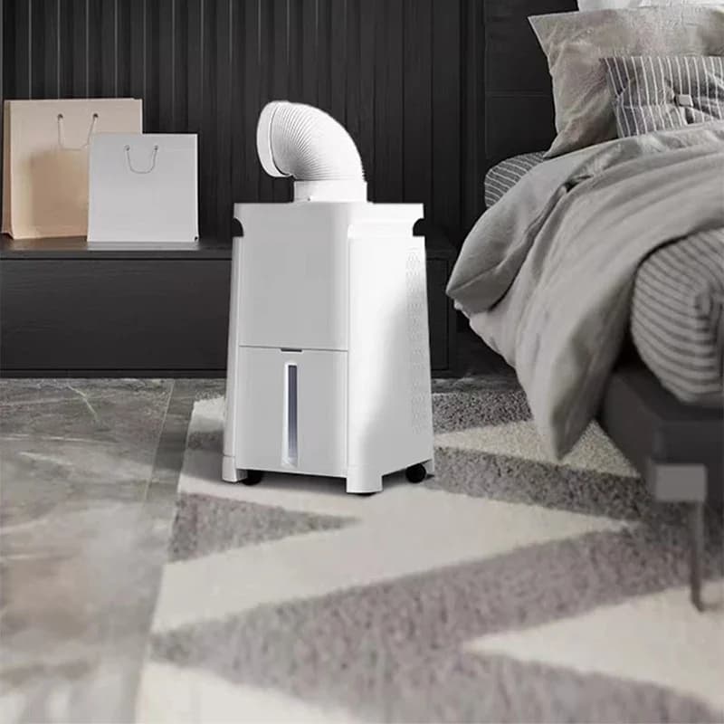 Ar condicionado portátil mini compressor cinza posicionado em quarto moderno ao lado da cama