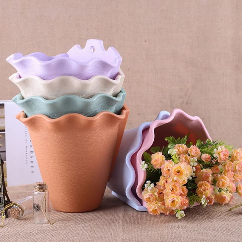 Vasos de flores Jácotei empilhados em plástico colorido com textura e borda ondulada