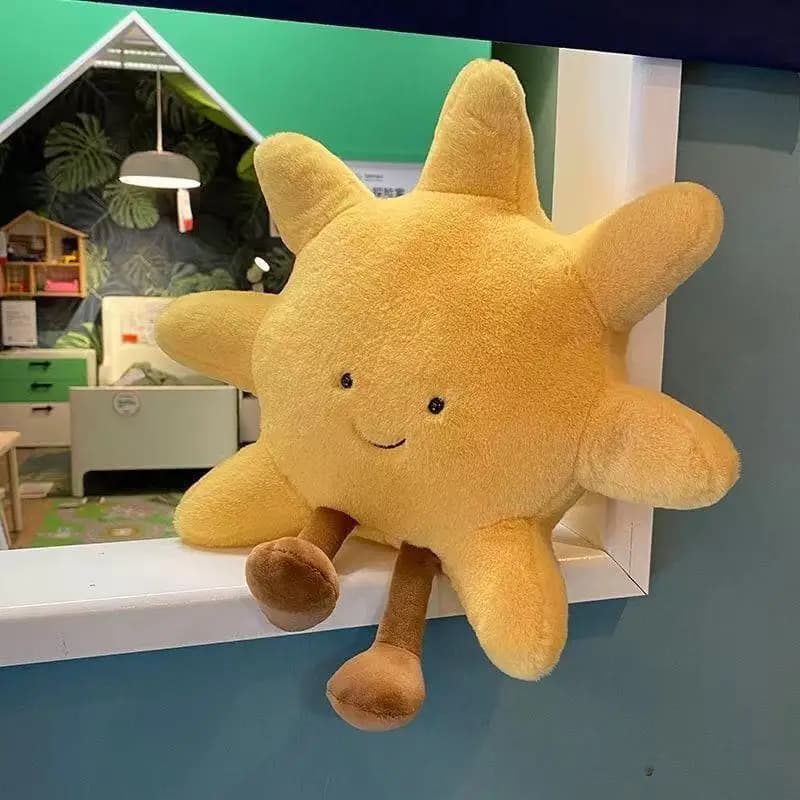 Almofada de pelúcia sol amarelo com rosto sorridente e pernas marrons em decoração infantil