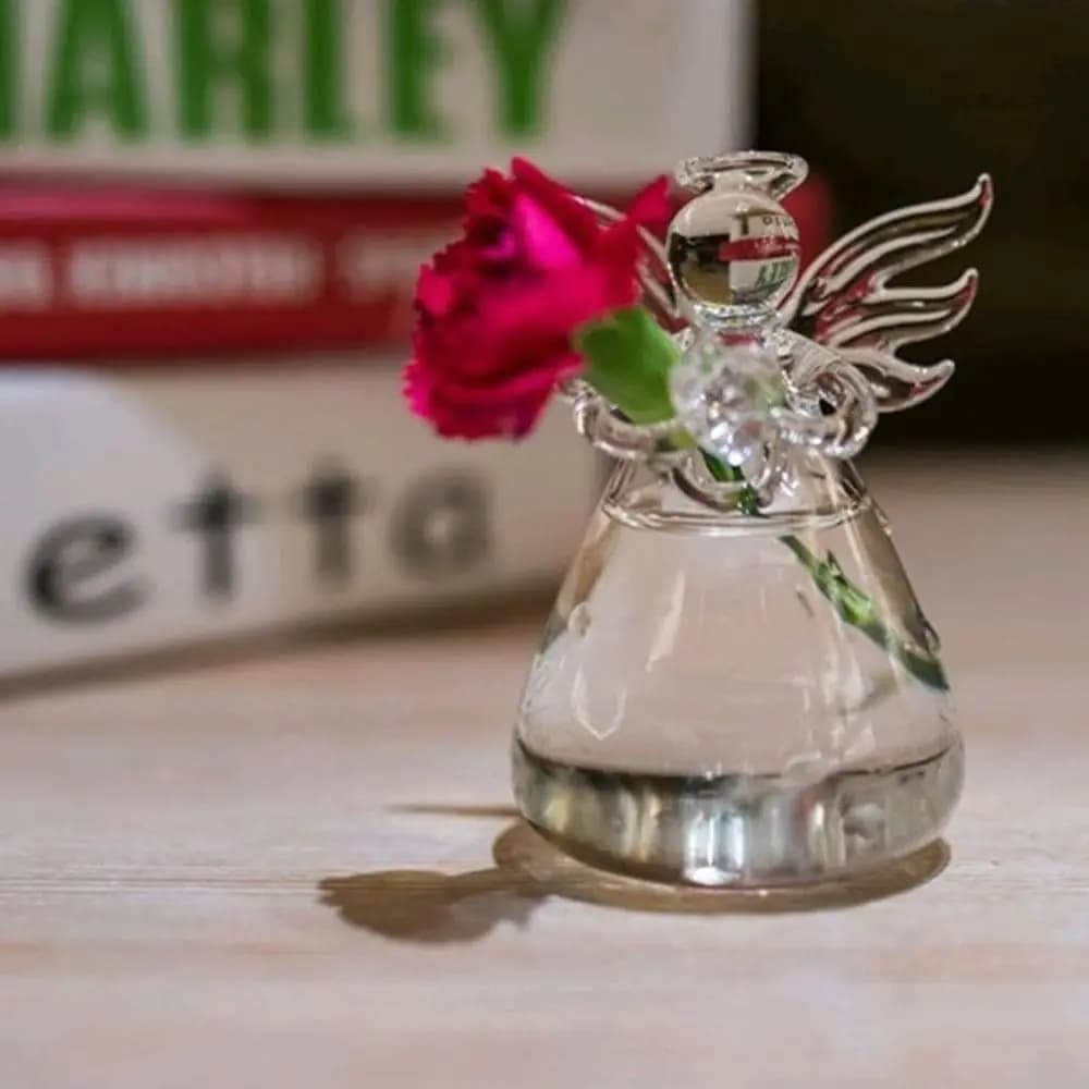 Vaso decorativo Jácotei anjo de vidro transparente com flor vermelha em mesa de madeira