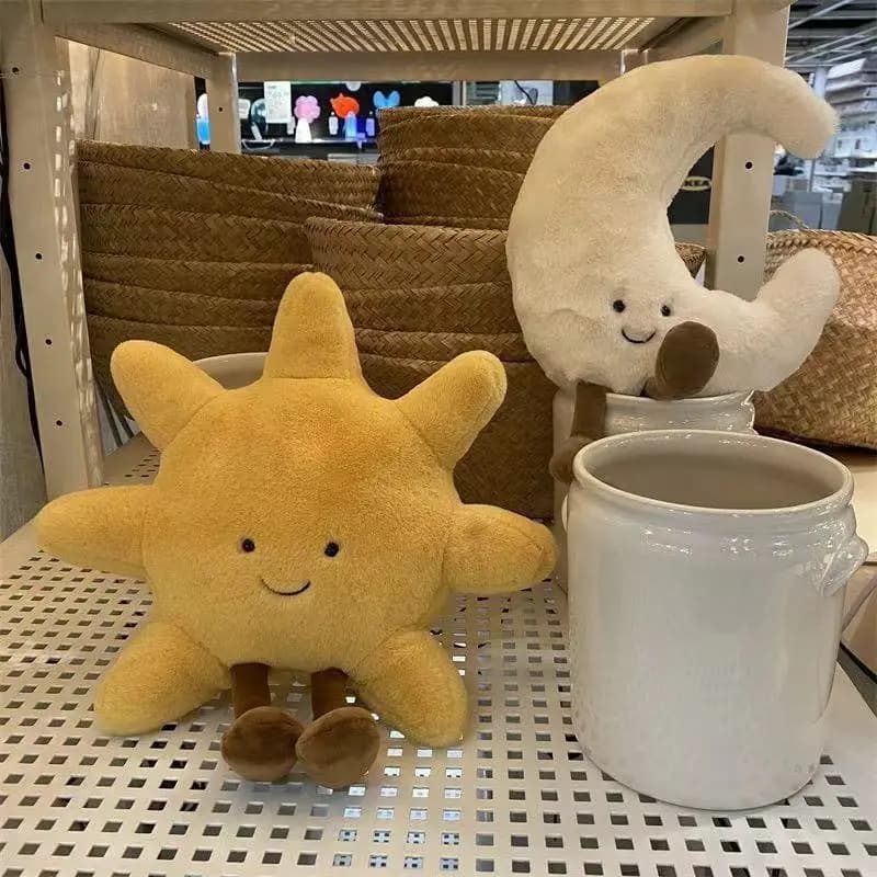 Almofadas decorativas sol amarelo e lua branca em pelúcia com rosto sorridente em prateleira
