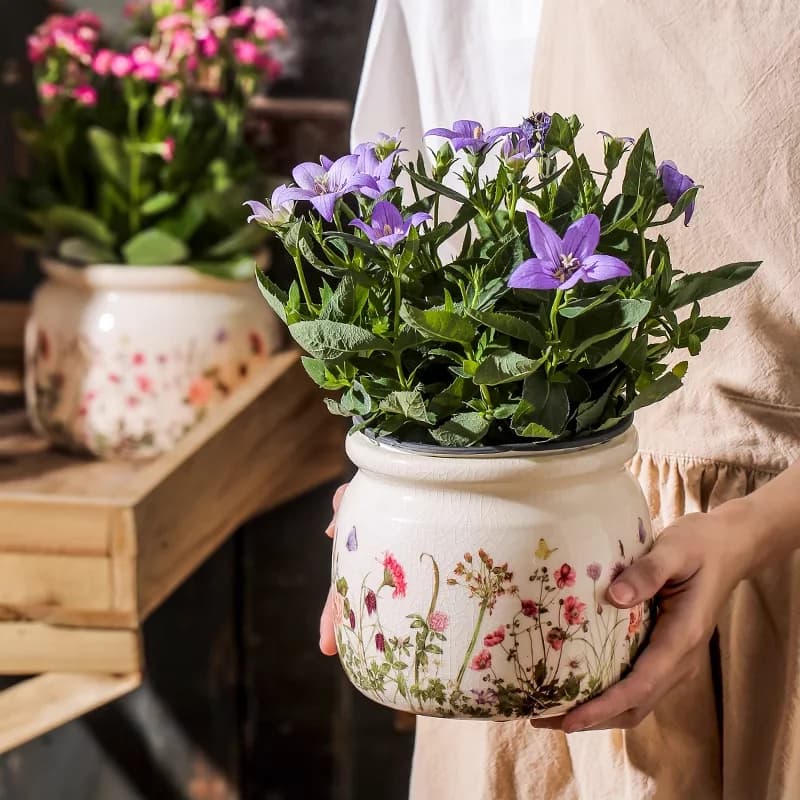 Vaso de cerâmica com flores lilases em padrão floral colorido