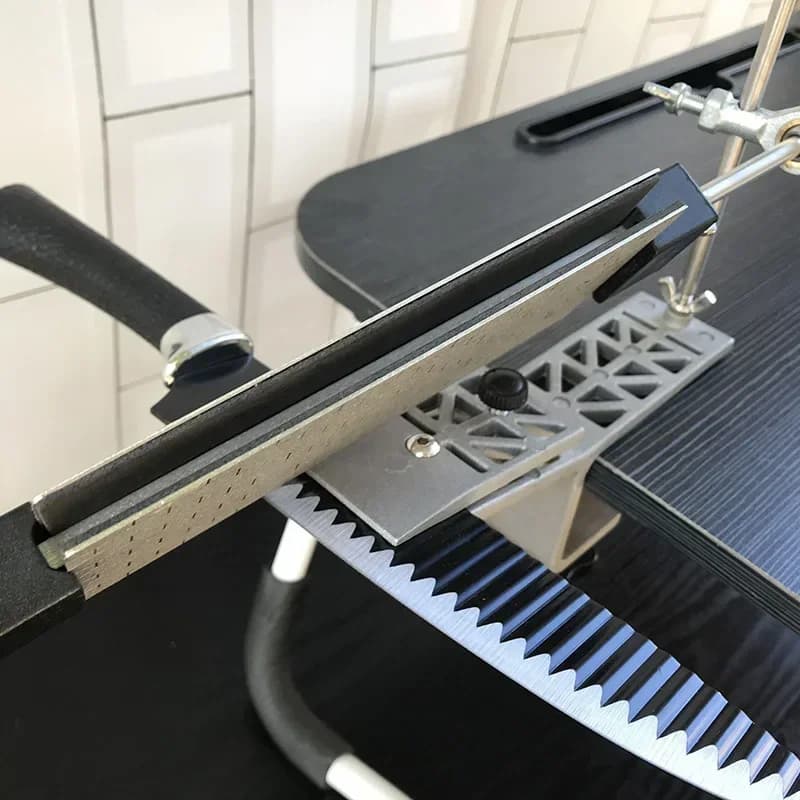 Afiador de faca profissional fixado em mesa, afiando lâmina serrilhada com suporte metálico