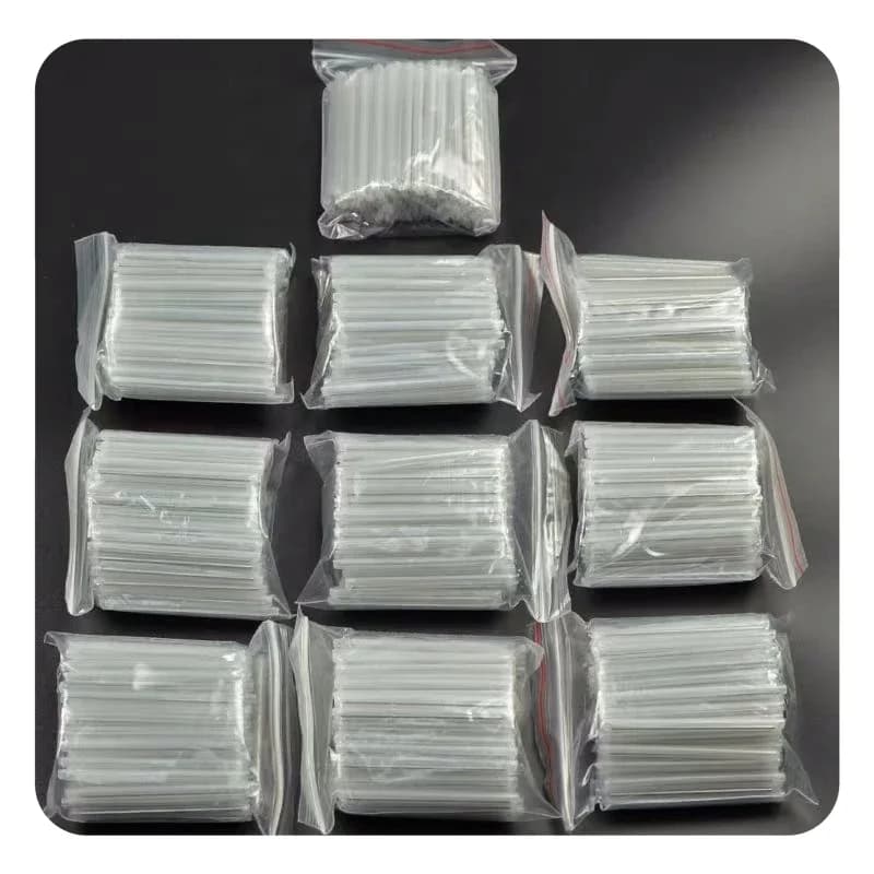 Pacotes com mangas de proteção transparentes para emenda de fibra óptica 1,2mm x 40mm organizados sobre superfície preta