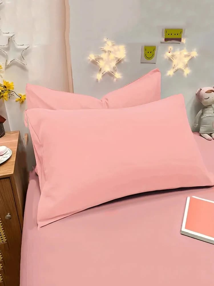 Fronha escovada macia rosa em cama com decoração de estrelas e brinquedo ao lado