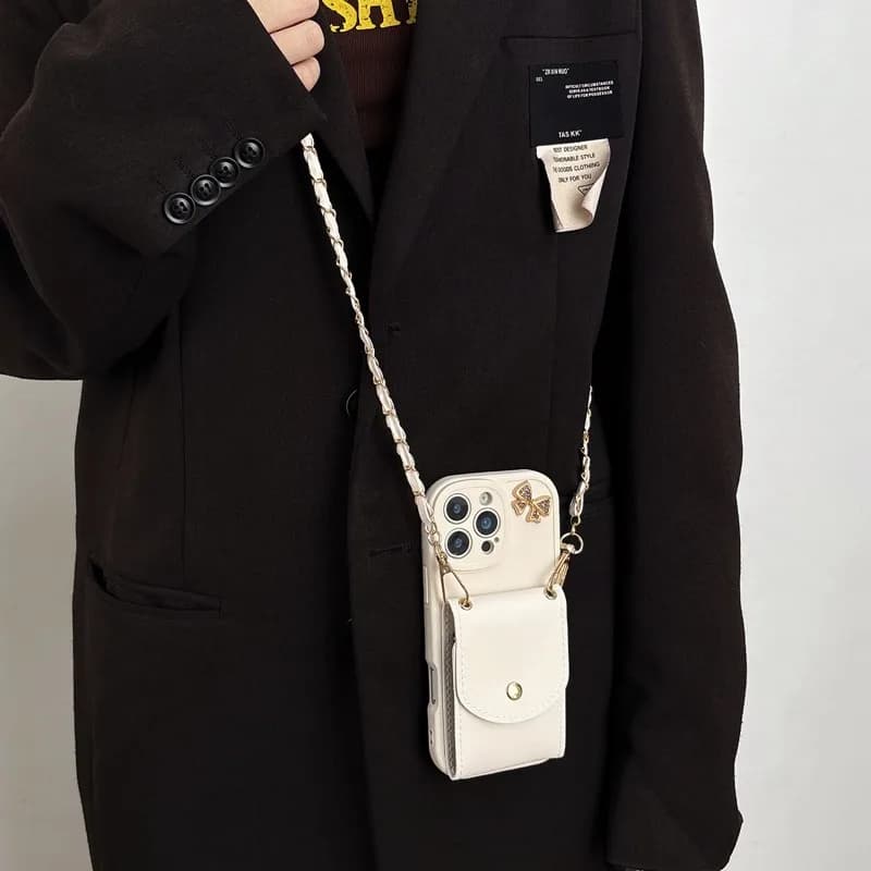 Capa branca para celular Poco com corrente e cadeado dourado, usada pendurada em blazer preto