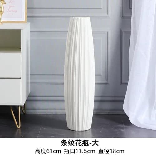 Vase decorativo branco minimalista com padrão geométrico em forma de diamante, com flores artificiais rosa.