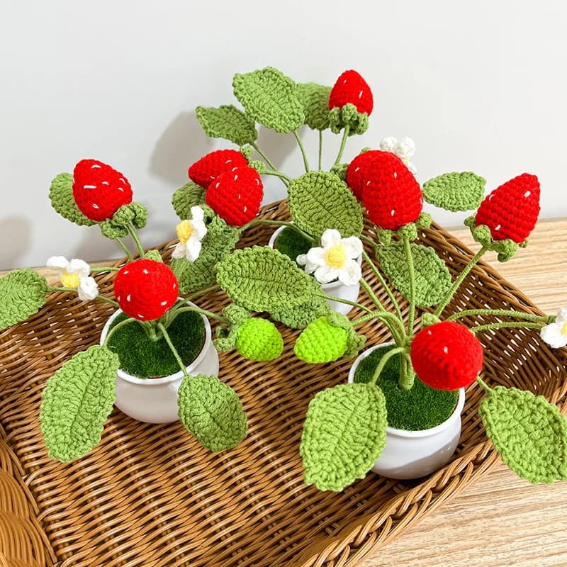 Plantas artificiais de morango em vasos brancos em uma cesta de vime