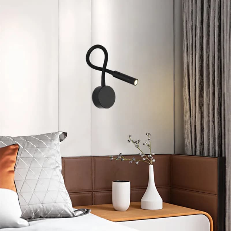 Arandela LED preta flexível gooseneck instalada em parede branca com decoração moderna ao lado da cama