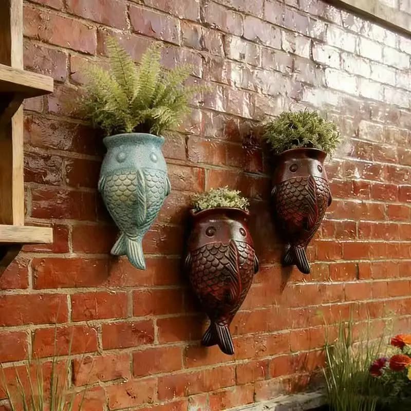 Vasos de parede em forma de peixe para plantas suculentas em uma parede de tijolos