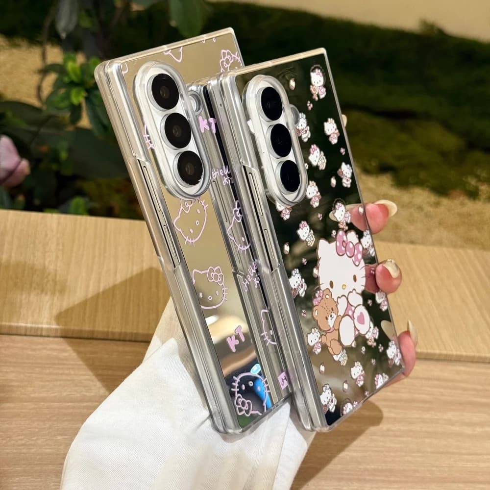 Duas capas para Galaxy Z Fold 7 espelhadas bege claro com estampas Hello Kitty e cordão trançado colorido