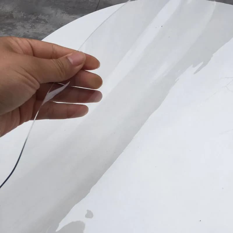 Mão segurando tapete de mesa redondo transparente em PVC flexível e resistente