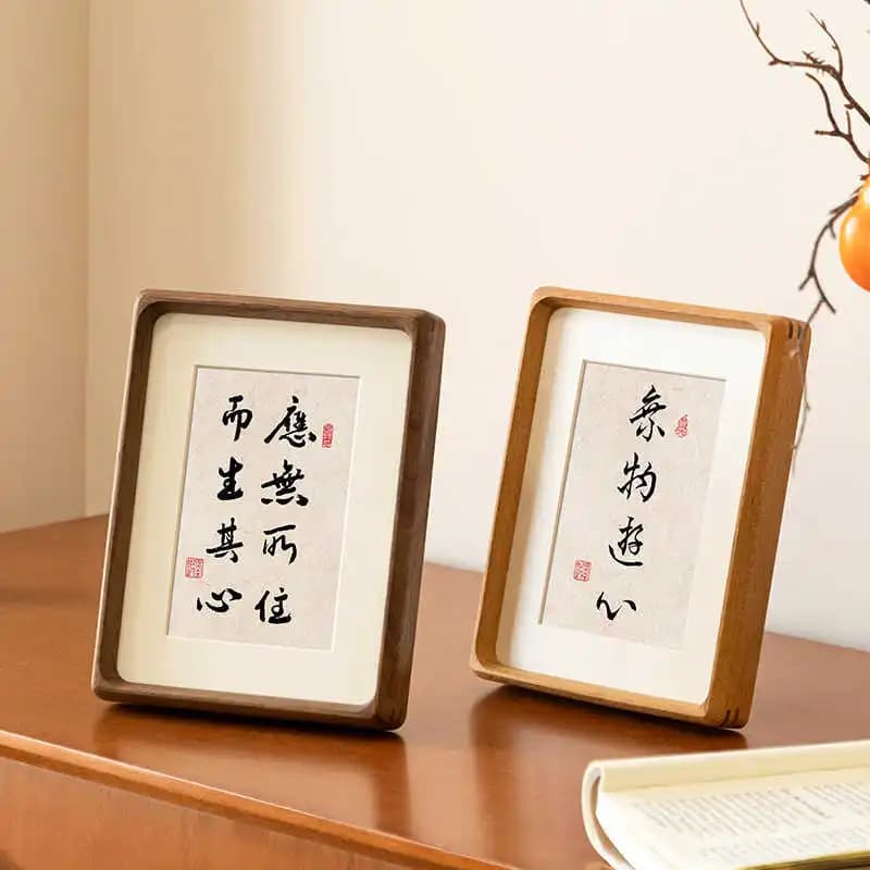 Dois quadros decorativos de madeira com texto chinês sobre uma mesa de madeira