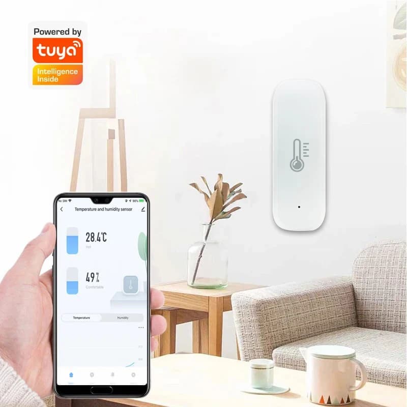 Sensor de temperatura e umidade Tuya Wifi branco instalado na parede com app mostrando dados no celular